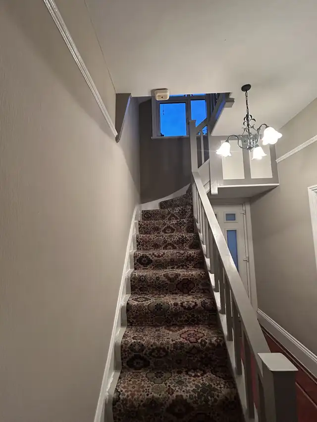 Freshly painted hallway and staircase with white spindles and grey walls