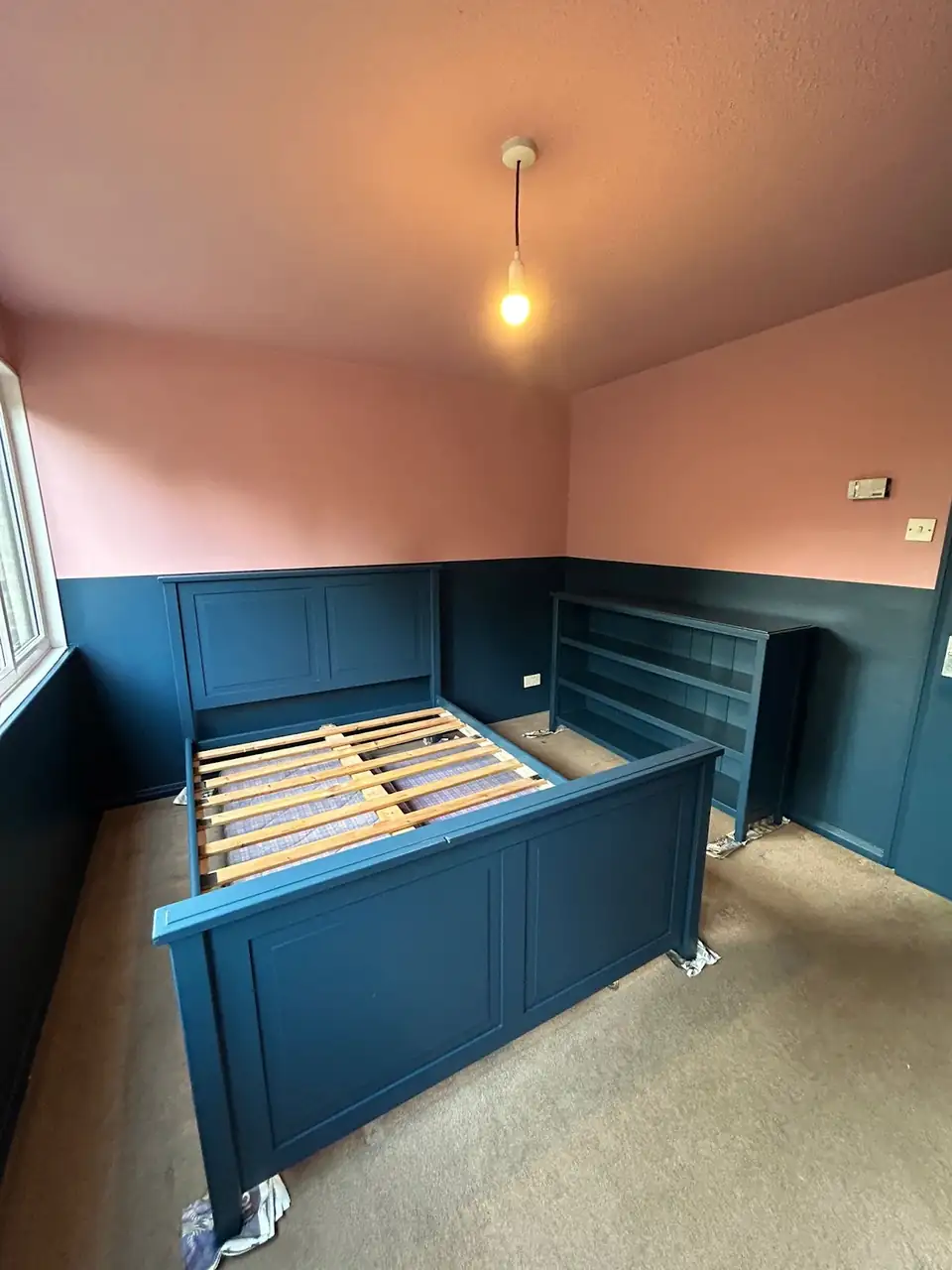 Bedroom in York with deep teal wall panelling and soft pink walls, decorated by MRK Decorating
