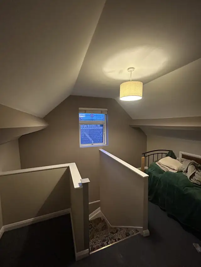 Loft bedroom painted in warm grey with white woodwork